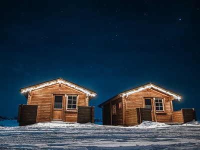 夜间在积雪覆盖的地面上建造褐色的木屋